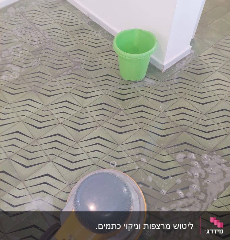 מכונת ניקוי רצפה ודלי ירוק על הרצפה